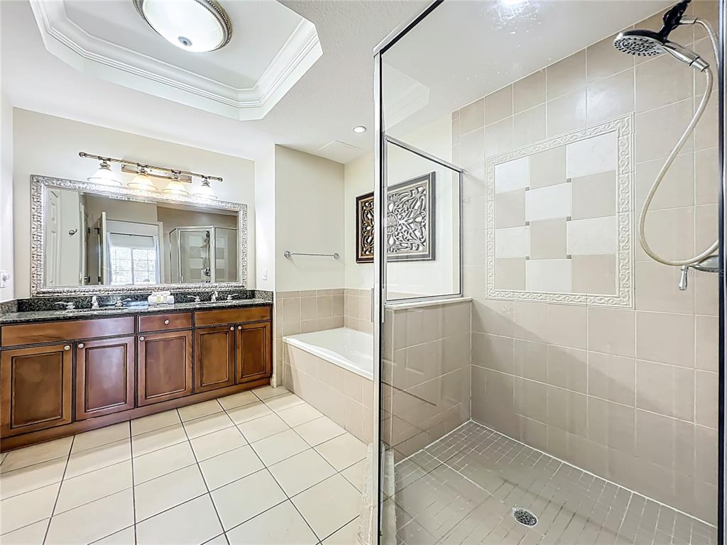 7660 Whisper Way, Unit 402 Reunion, FL 34747 - Photo 37 of 65 a bathroom with a granite countertop sink a mirror and a shower
