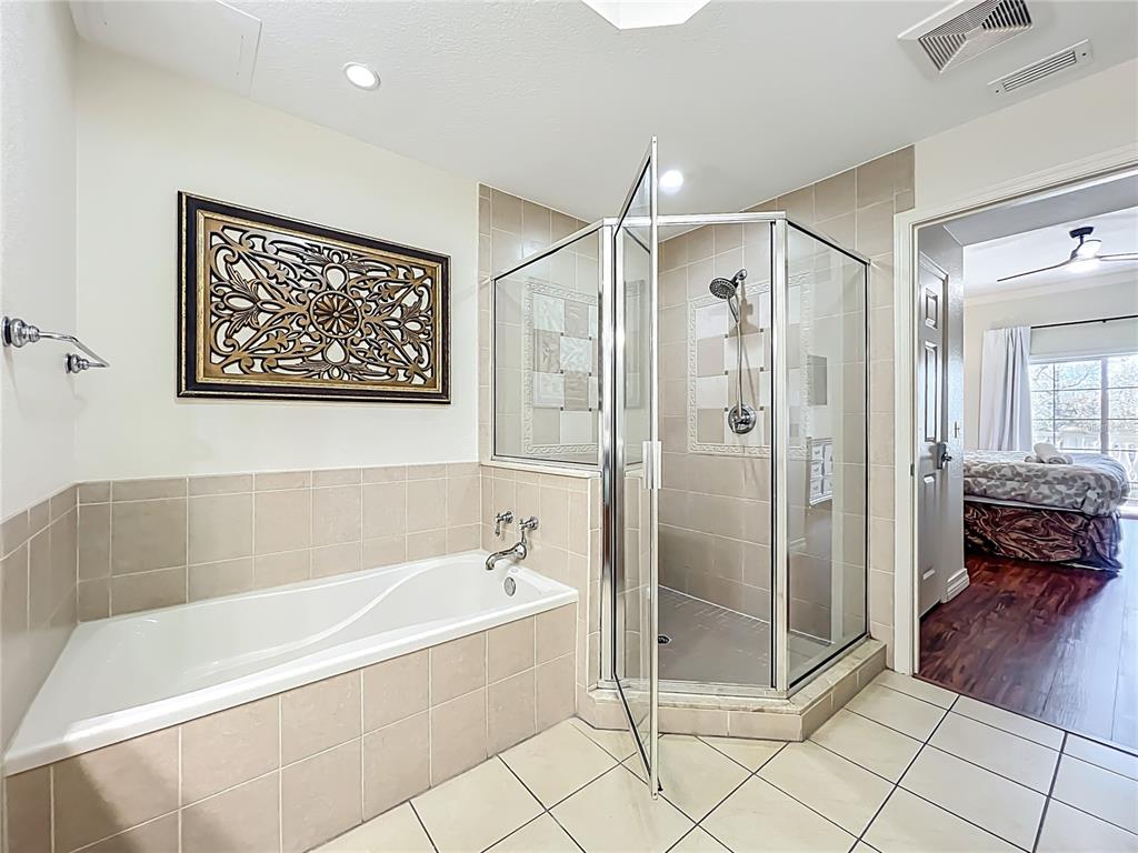 7660 Whisper Way, Unit 402 Reunion, FL 34747 - Photo 39 of 65 a spacious bathroom with a glass shower a bathtub and a shower