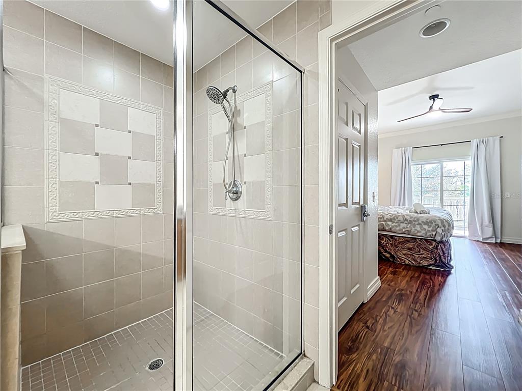 7660 Whisper Way, Unit 402 Reunion, FL 34747 - Photo 40 of 65 a view of a bathroom with a glass door shower and a mirror
