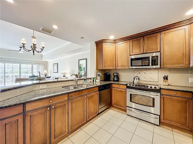 a kitchen with stainless steel appliances granite countertop a sink and a stove