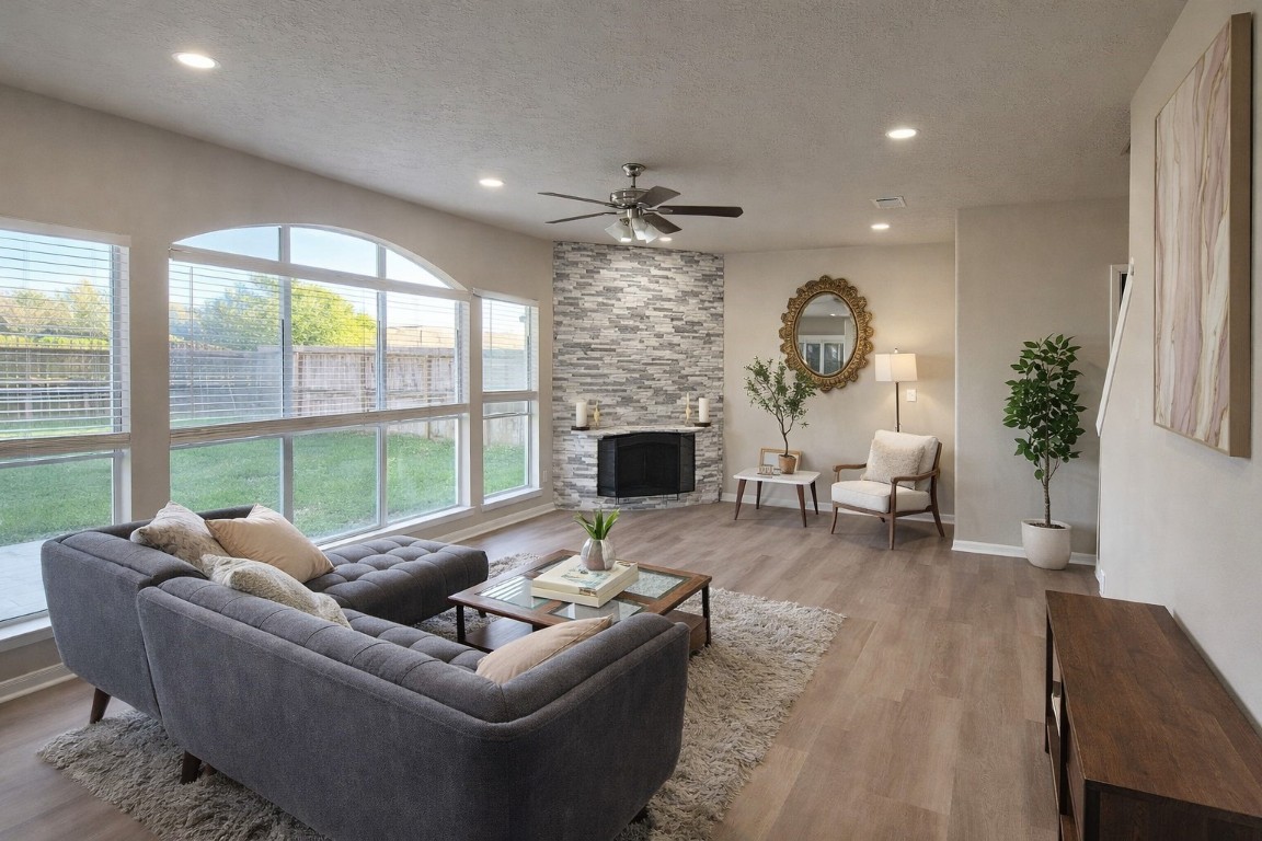 a living room with furniture a fireplace and a floor to ceiling window