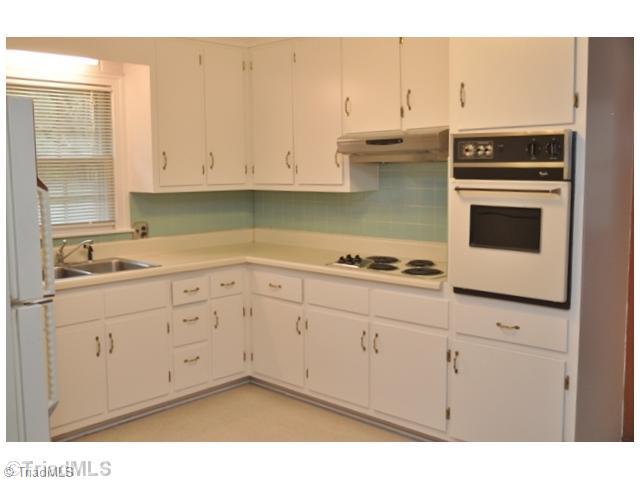 421 Kyle Road Winston-Salem, NC 27104 - Photo 9 of 16 Kitchen. The charming cottage-style kitchen features a built-in wall oven, deep double sinks, and aqua tile backsplash.