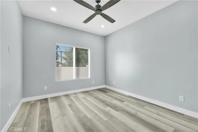 an empty room with a window and a ceiling fan