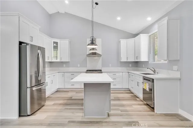 a kitchen with kitchen island white cabinets and stainless steel appliances