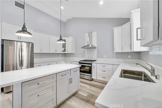 a kitchen with white cabinets stainless steel appliances and sink