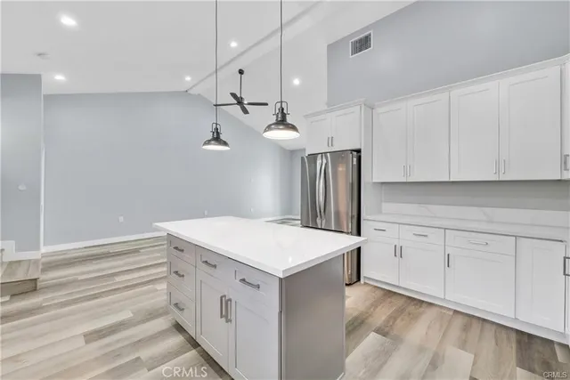 a kitchen with cabinets appliances and a wooden floor