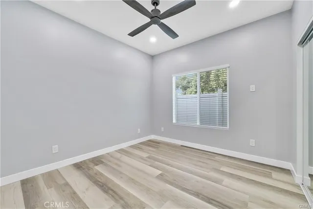 an empty room with a window and a ceiling fan
