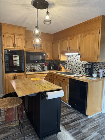 a kitchen with stainless steel appliances granite countertop wooden cabinets a stove a sink and a refrigerator