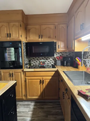 a kitchen with stainless steel appliances granite countertop a sink stove and cabinets