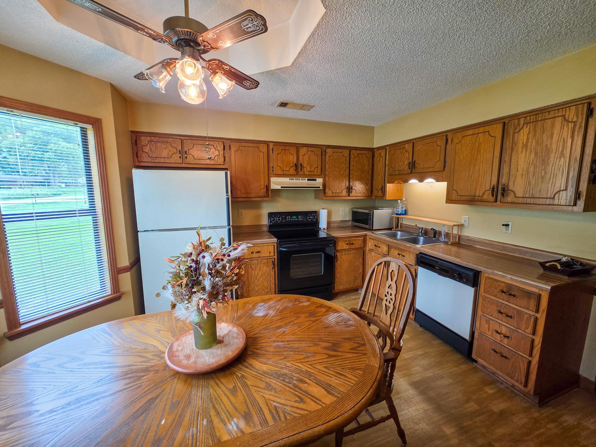 966 Beaver Road Munford, TN 38058 - Photo 11 of 32 Kitchen featuring wood-finish cabinetry, black appliances, double basin sink, and a ceiling fan with integrated lighting