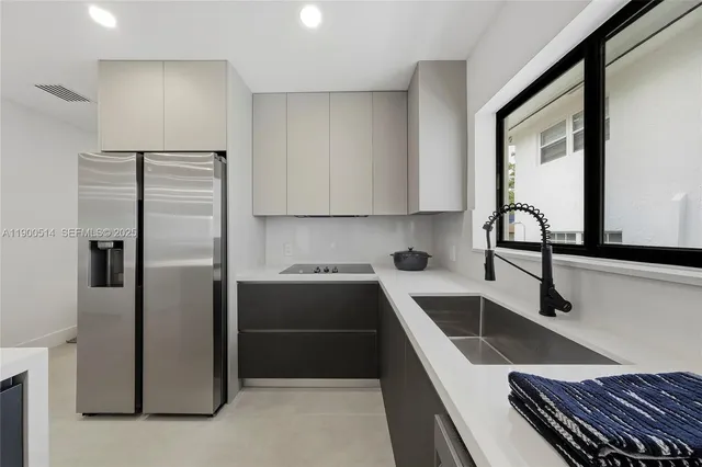 a kitchen with kitchen island a sink stainless steel appliances and cabinets