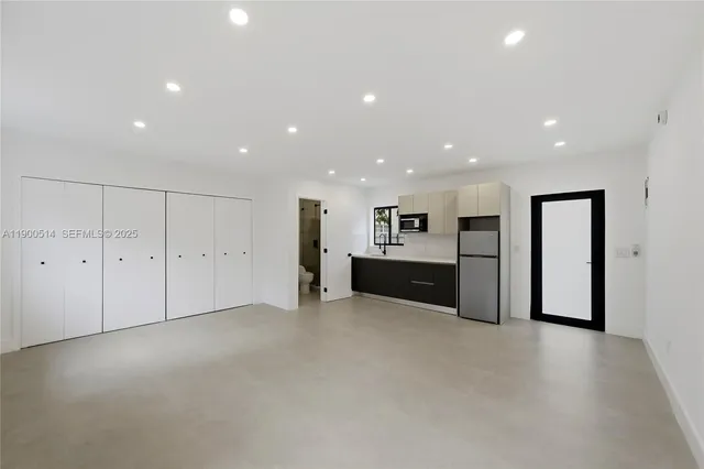 a kitchen with kitchen island a counter top space cabinets and stainless steel appliances