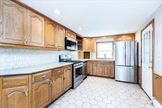 a kitchen with stainless steel appliances granite countertop a refrigerator and a stove top oven