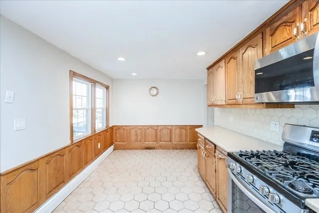 a kitchen with stainless steel appliances granite countertop a stove a sink and a microwave