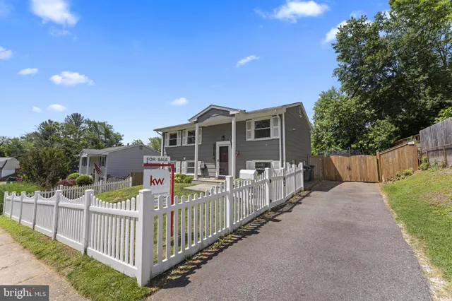 a view of a house with wooden fence and trees