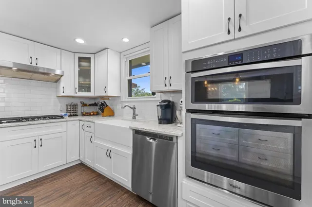 a kitchen with stainless steel appliances granite countertop a stove microwave and cabinets