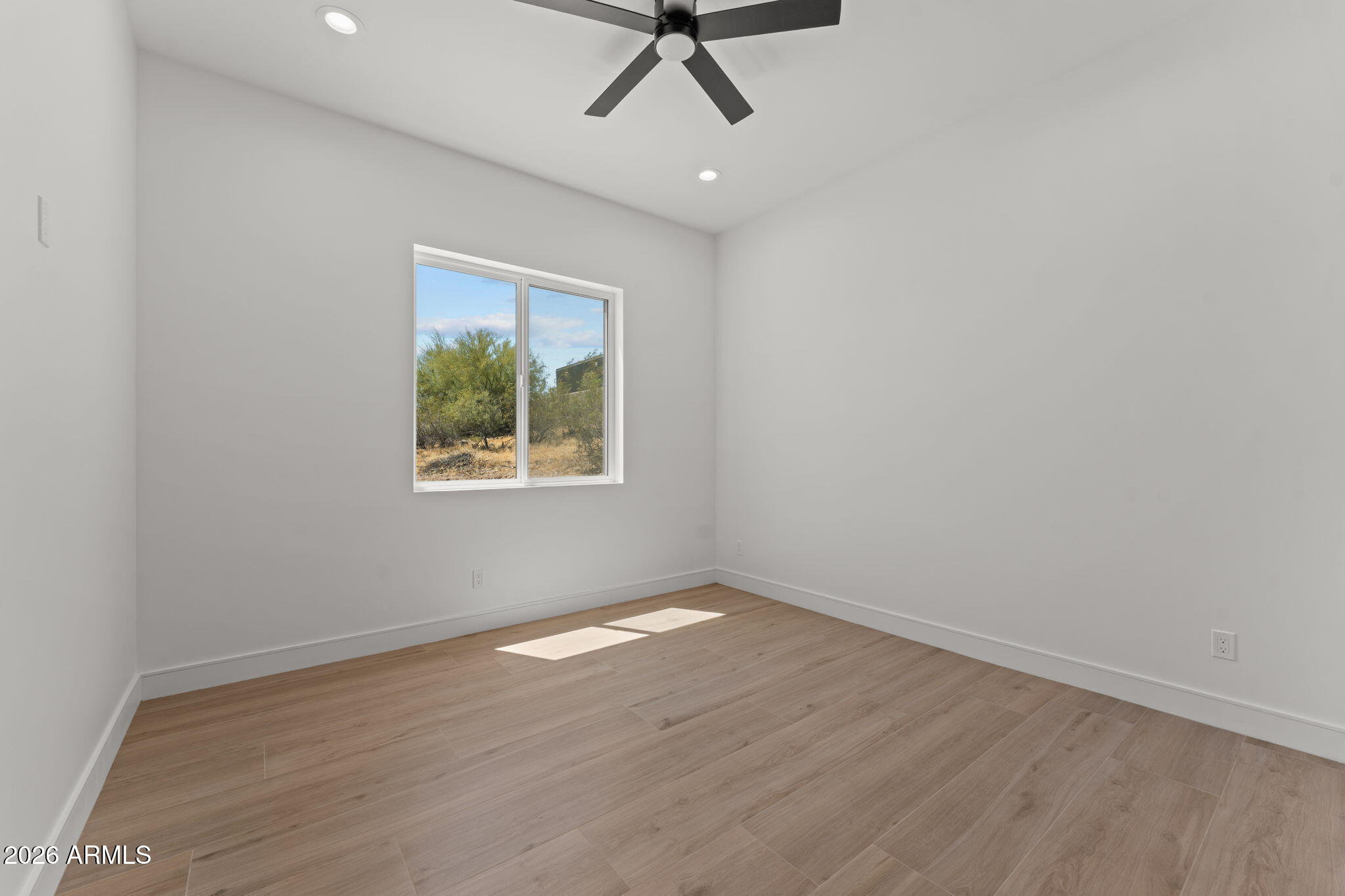 2855 Percheron Road Wickenburg, AZ 85390 - Photo 38 of 58 an empty room with wooden floor ceiling fan and windows