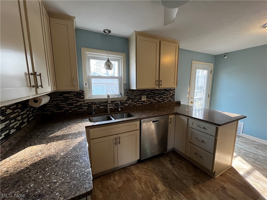 30824 Clarmont Road Willowick, OH 44095 - Photo 13 of 24 Kitchen featuring stainless steel dishwasher, sink, tasteful backsplash, kitchen peninsula, and pendant lighting