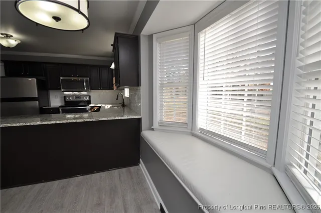 a view of an empty room with window and fire place