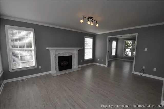 wooden floor fireplace and windows in an empty room