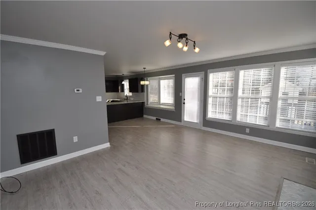 a view of empty room with wooden floor and fireplace
