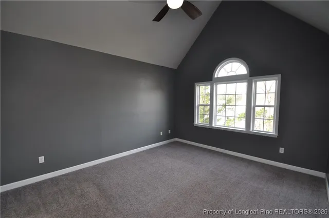 en empty room with windows and chandelier fan