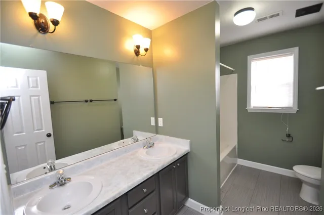 a bathroom with a tub shower and a sink