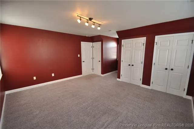 a view of an empty room with a chandelier fan