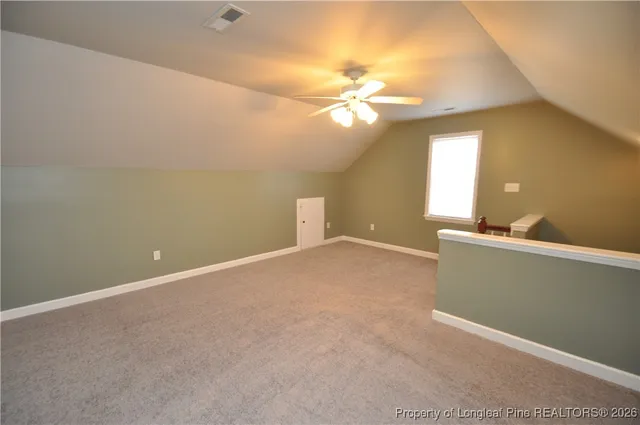 a view of an empty room with a chandelier fan