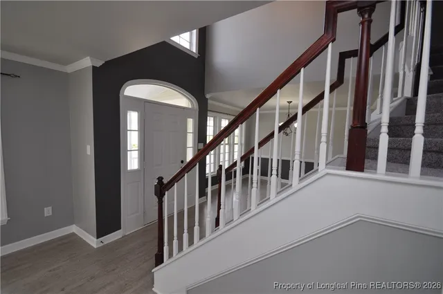 a view of staircase with wooden floor and fan