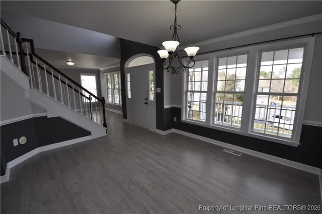 a view of a room with wooden floor and furniture