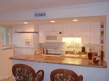 a kitchen with large window appliances and cabinets