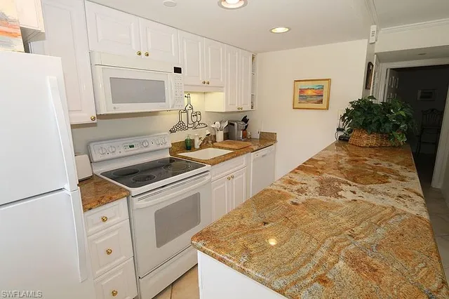 a kitchen with white cabinets and white appliances