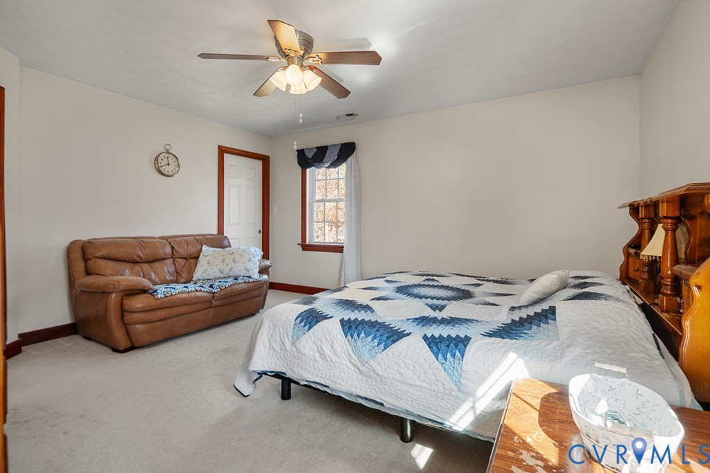 7601 Amelia Springs Road Jetersville, VA 23083 - Photo 7 of 21 a bedroom with a bed and a chandelier