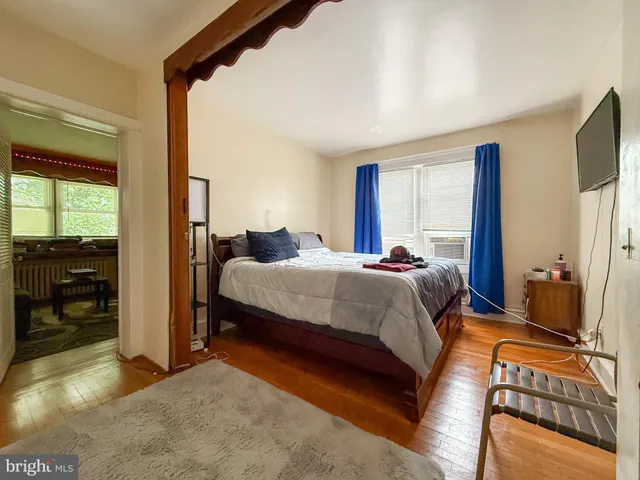a bedroom with a bed and large windows