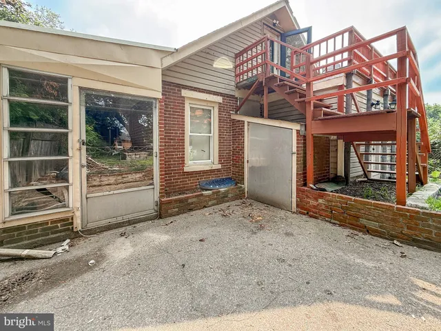 a view of a house with a door and wooden fence