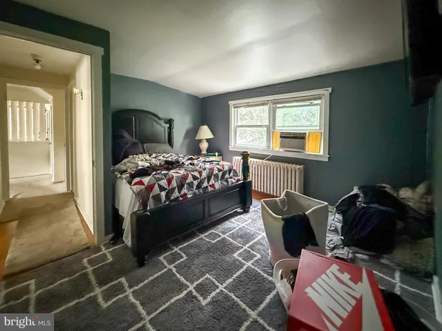 a bedroom with a bed chair and window