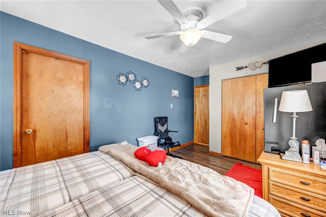 3830 Jerusalem Road Vermilion, OH 44089 - Photo 28 of 49 Bedroom featuring a closet, a textured ceiling, wood finished floors, and ceiling fan