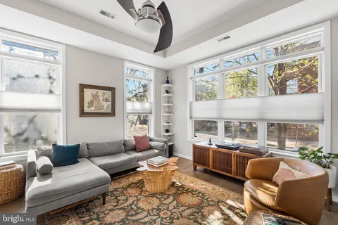 a living room with furniture fireplace and a large window