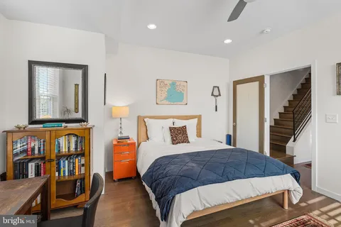 a bedroom with a bed a dresser and book shelf