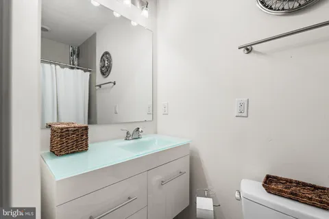 a bathroom with a sink a toilet and a mirror