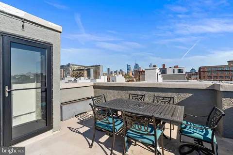 a roof deck with table and chairs