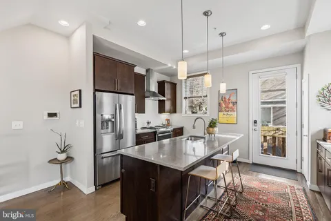 a kitchen with kitchen island a counter top space appliances and a dining table