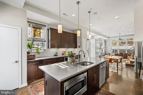 a kitchen with a sink stove and wooden floor