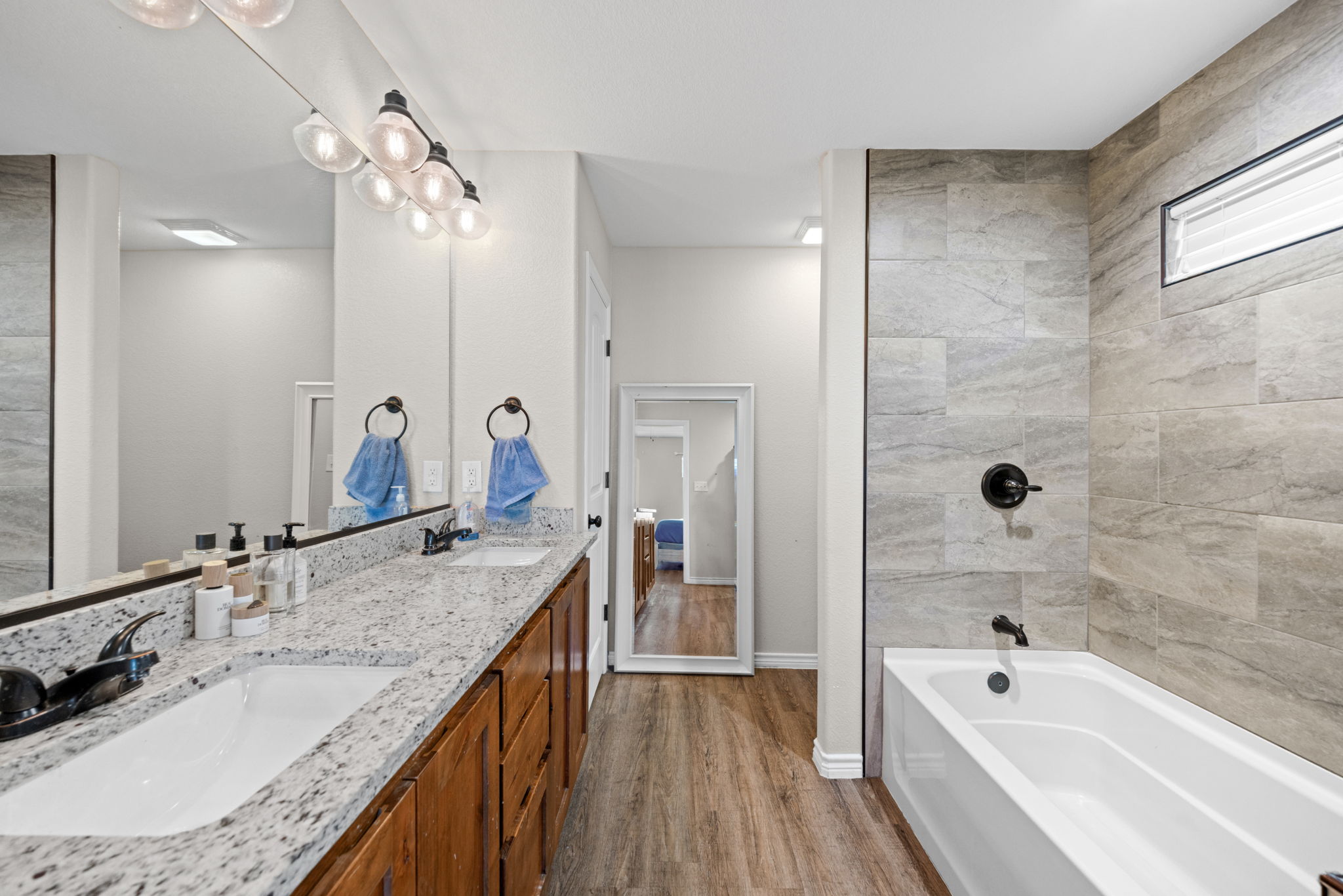 1313 Sandstone Cove Lampasas, TX 76550 - Photo 6 of 25 a bathroom with a granite countertop sink a bathtub a mirror and shower