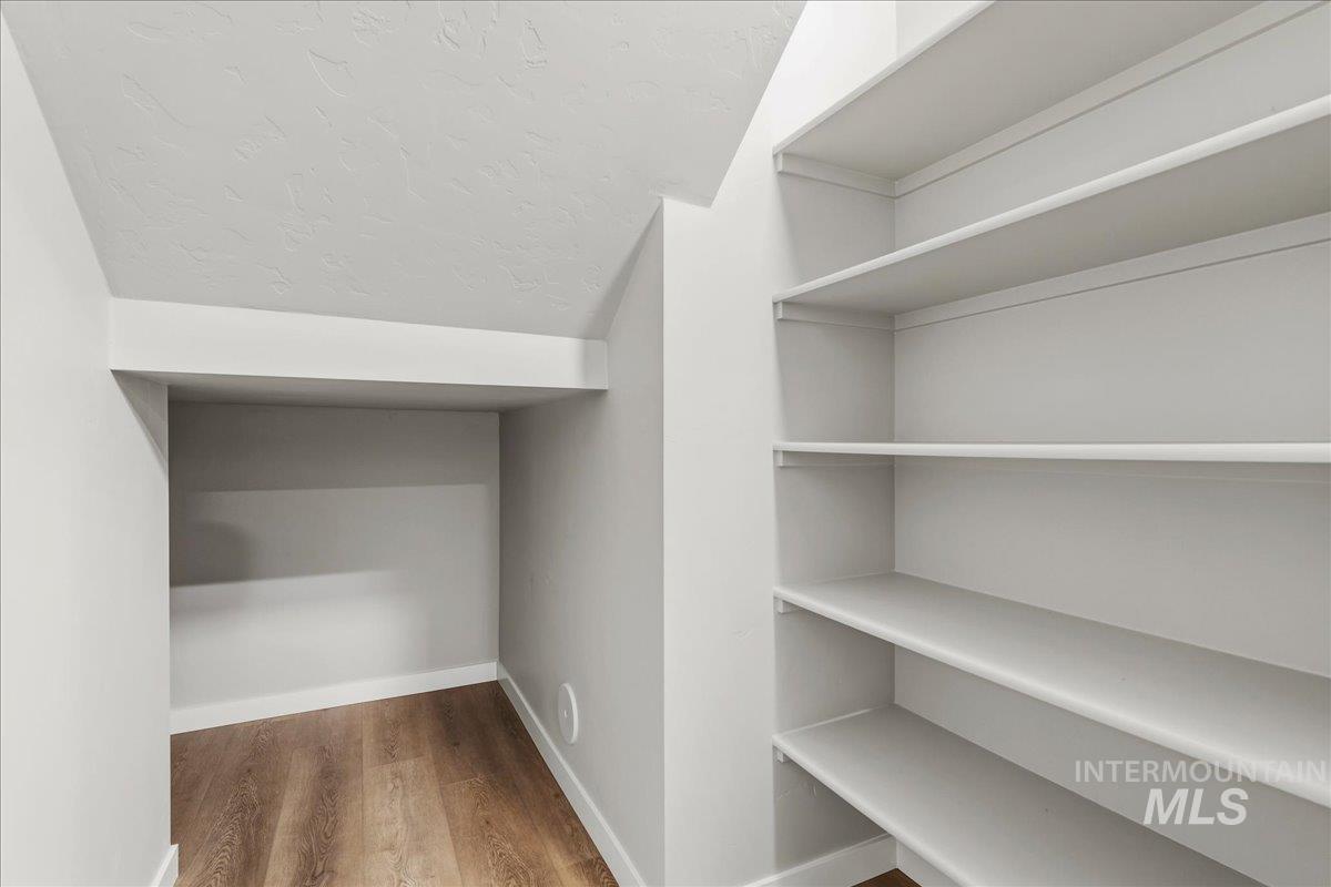 12475 West Victory Road Boise, ID 83709 - Photo 14 of 26 Built-in shelving units with white finish, wood-finish flooring, and white baseboards