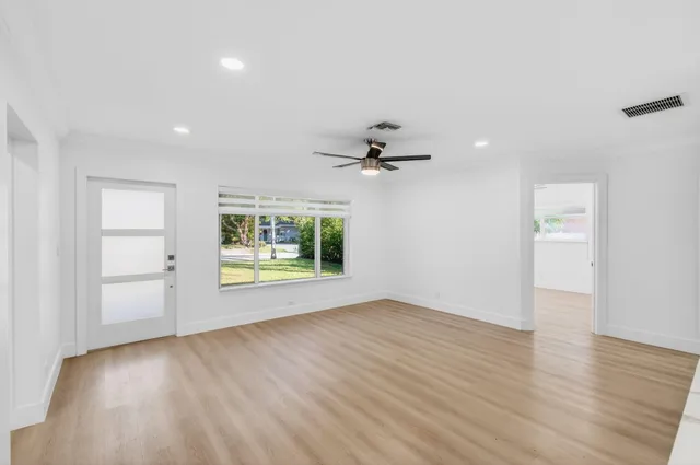 a kitchen with stainless steel appliances kitchen island granite countertop a sink a stove and a wooden floors