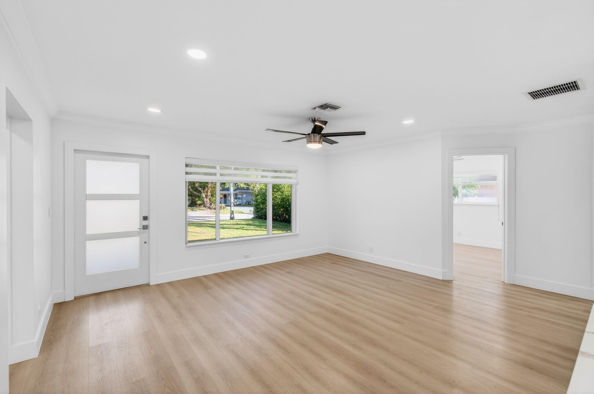 360 Southwest 2nd Street Boca Raton, FL 33432 - Photo 12 of 100 an empty room with wooden floor chandelier fan and windows