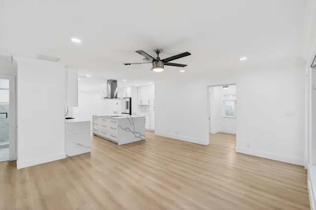 a view of a livingroom with a ceiling fan and wooden floor