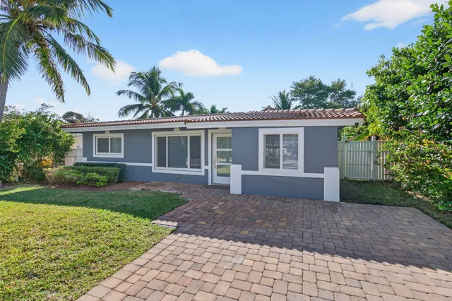 an empty room with wooden floor chandelier fan and windows